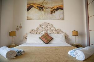 a bedroom with a white bed with towels on it at Ninfa Apartment - Taormina Holidays in Taormina