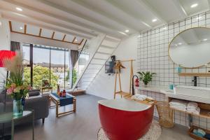 苏州Tongli Slowlife River View Inn的一间位于客房内的带大型红色浴缸的浴室