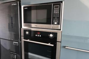 a microwave and two ovens in a kitchen at Sky Star Villa 25 in Hurghada
