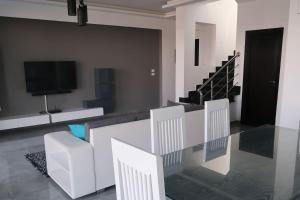 sala de estar con sillas blancas y TV en Sky Star Villa 25 en Hurghada