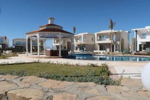 a gazebo next to a swimming pool with houses at Sky Star Villa 25 in Hurghada