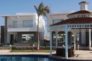 une maison avec un kiosque à côté d'une piscine dans l'établissement Sky Star Villa 25, à Hurghada