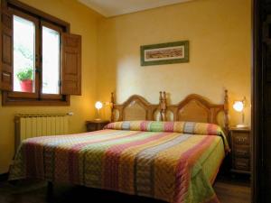 a bedroom with a bed with a striped blanket at Apartamentos Pistolo in Ochagavía