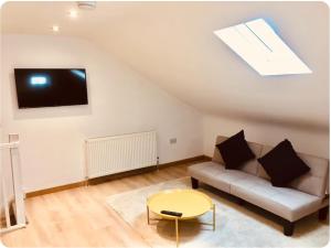 a living room with a couch and a tv at Oak Tree Studio in Marlow