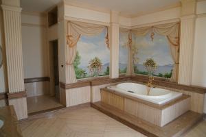 a large bathroom with a tub and a window at Villa Princi in Villa San Giovanni