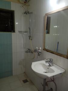 a bathroom with a sink and a shower with a mirror at Bella Pensao in Parra