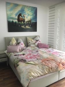 una camera da letto con un letto e un dipinto sul muro di Apartment Elfi a Leibnitz