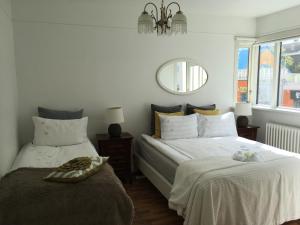 a bedroom with two beds and a mirror on the wall at Skólavörðustígur Apartments in Reykjavík