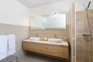 Bleu Emeraude Hotel في غراند كيس: حمام به مغسلتين ومرآة كبيرة