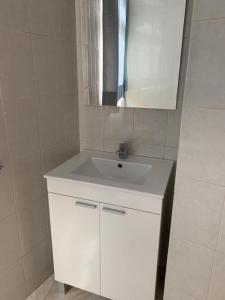a bathroom with a white sink and a mirror at TABLERO 303, FABULOSO apto 6 pax cerca de PLAYA INGLÉS in El Tablero