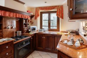 a kitchen with wooden cabinets and a stove top oven at Maison Paquier - Central Family Escape in Valtournenche