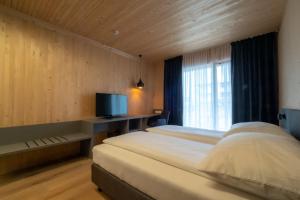 1 dormitorio con 1 cama grande y TV en GästeHAUS & HOFladen Familie Öllerer, en Sitzenberg