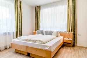 a bedroom with a wooden bed in front of a window at Gasthof - Restaurant Bernthaler in Deutschfeistritz