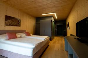 1 dormitorio con 2 camas y TV. en GästeHAUS & HOFladen Familie Öllerer, en Sitzenberg