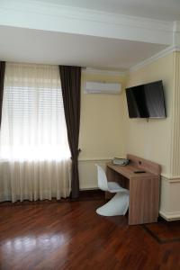 a room with a desk and a television on the wall at Villa Princi in Villa San Giovanni