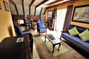 a living room with a couch and chairs and a table at Emzini Apartments in Midrand