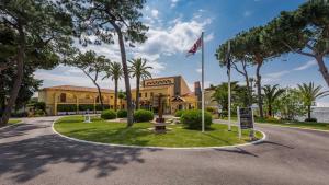 a road in front of a building with a flag at Macdonald Leila Playa Resort in La Cala de Mijas