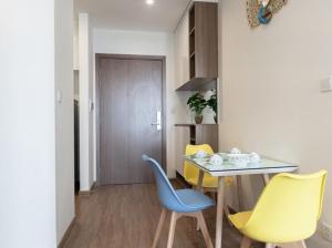 ein Esszimmer mit einem Tisch und gelben Stühlen in der Unterkunft Vinhome Skylake apartment 1 in Hanoi
