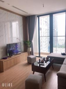 ein Wohnzimmer mit einem Sofa und einem TV in der Unterkunft Vinhome Skylake apartment 1 in Hanoi