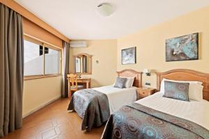 a hotel room with two beds and a window at Macdonald Leila Playa Resort in La Cala de Mijas