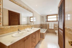 a bathroom with two sinks and a tub and a toilet at Macdonald Leila Playa Resort in La Cala de Mijas