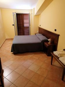 1 dormitorio con 1 cama y 1 mesa en La nuova locanda, en Orsomarso