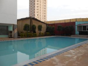 a large blue swimming pool with a tall building at Hotel Siddharth in Varanasi