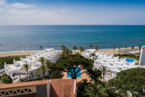 a view of a beach with white lounge chairs and the ocean at Macdonald Leila Playa Resort in La Cala de Mijas