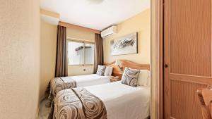 two beds in a hotel room with two beds sidx sidx sidx at Macdonald Leila Playa Resort in La Cala de Mijas