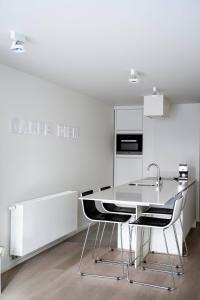 - une cuisine blanche avec une table et deux chaises dans l'établissement Carpe diem Noguchi 201- Adults Only, à Saint-Idesbald