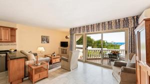 a kitchen and living room with a large sliding glass door at Macdonald Leila Playa Resort in La Cala de Mijas