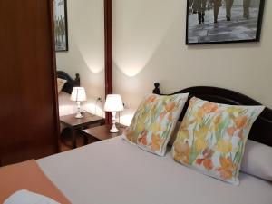 a bedroom with a bed with two pillows and two lamps at PISO DE CALIDAD EN EL CENTRO DEL CENTRO DE GIJON in Gijón