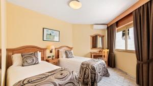 a hotel room with two beds and a window at Macdonald Leila Playa Resort in La Cala de Mijas