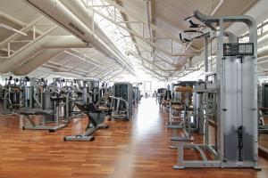 ein Fitnessstudio mit vielen Laufbändern und Geräten in der Unterkunft Scheck Hotel in München