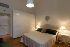 een slaapkamer met een wit bed en een groen kussen bij AD Verona flat in Verona