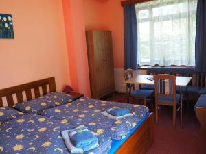 1 Schlafzimmer mit 2 Betten, einem Tisch und Stühlen in der Unterkunft Apartmán Borůvka in Špindlerův Mlýn