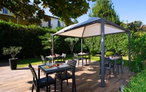 a group of tables and chairs under an umbrella at Hotel San Francisco in Milan