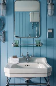 a bathroom with a white sink and a mirror at The Swan Hotel in Southwold