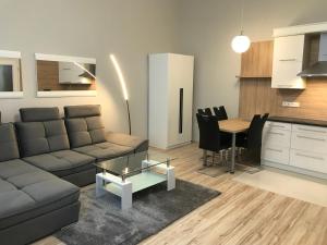 uma sala de estar com um sofá e uma mesa em Bervia Apartman em Szombathely