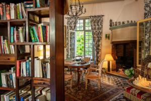 een kamer met een tafel en boekenplanken gevuld met boeken bij Hôtel La Casa Pairal in Collioure
