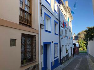 a blue and white building on a narrow street at Casa Jovellanos de Casas Das Figueiras en Ría Eo-Ribadeo in Castropol