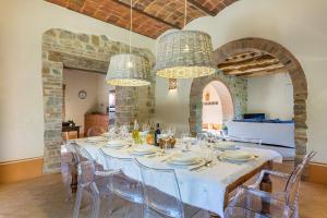 a dining room with a table with chairs and chandeliers at Villa Casenovole in Murlo