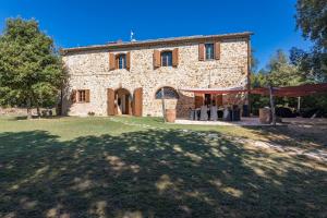 an old stone house with a large yard in front of it at Villa Casenovole in Murlo