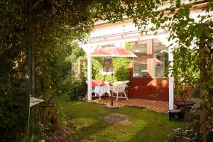 un cenador blanco con una mesa en un patio en Bed & Breakfast Wesseloh, en Schneverdingen