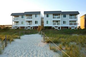a building on the beach next to a sandy beach at Next 2 Paradise-203 in Holden Beach