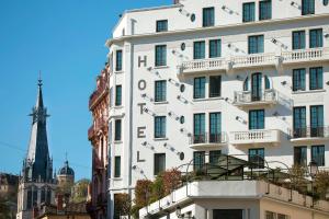 a white building with signs on the side of it at Collège Hôtel in Lyon