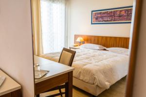 1 dormitorio con cama, mesa y escritorio en Europa Palace Hotel, en Messina