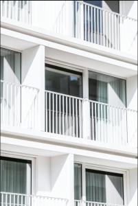 a white building with balconies on it at Carpe diem Noguchi 201- Adults Only in Sint-Idesbald