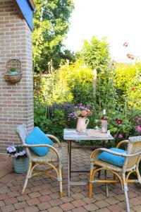 a patio with two chairs and a table with at Wuytershoef in Dilsen-Stokkem