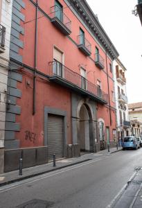 un edificio rosso sul lato di una strada di Solimena House a Nocera Inferiore